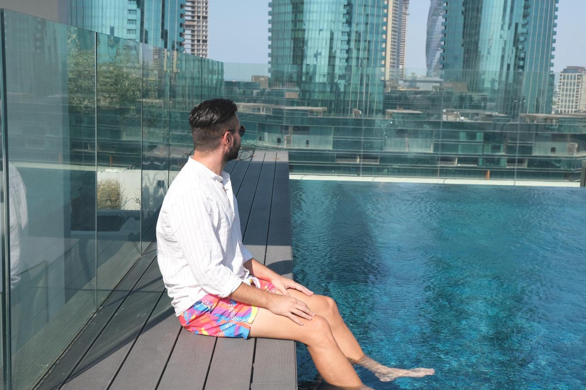Charthouse Bahrain Hotel Manama Exterior photo A man sitting on the edge of a pool